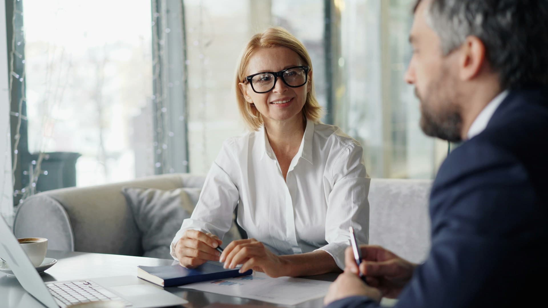 women sitting on a table with a estate agent